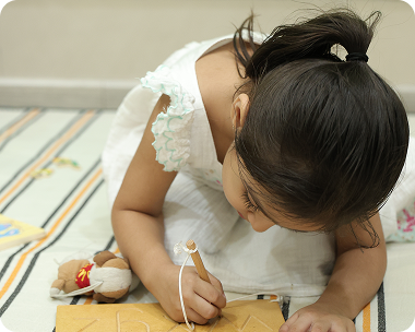 Small girl learning to read and write at Zack's tuition class in Surat